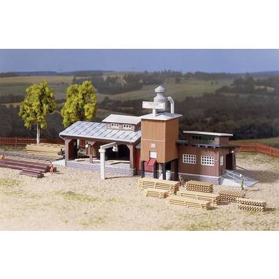 Model of a timber processing factory with buildings, stacks of wooden planks and people in a rural setting.