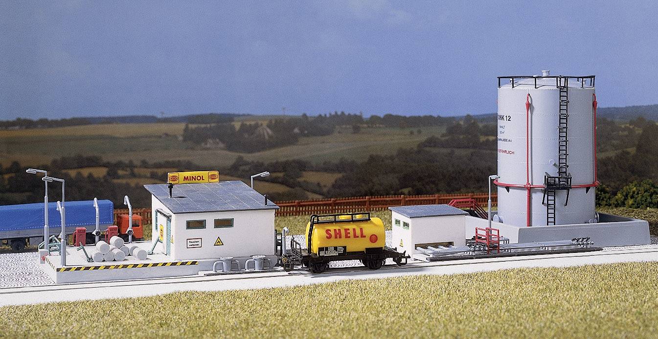 Small model layout with petrol station: Building with 'Minol' sign, tanker truck with 'Shell' inscription and large circular storage tank.