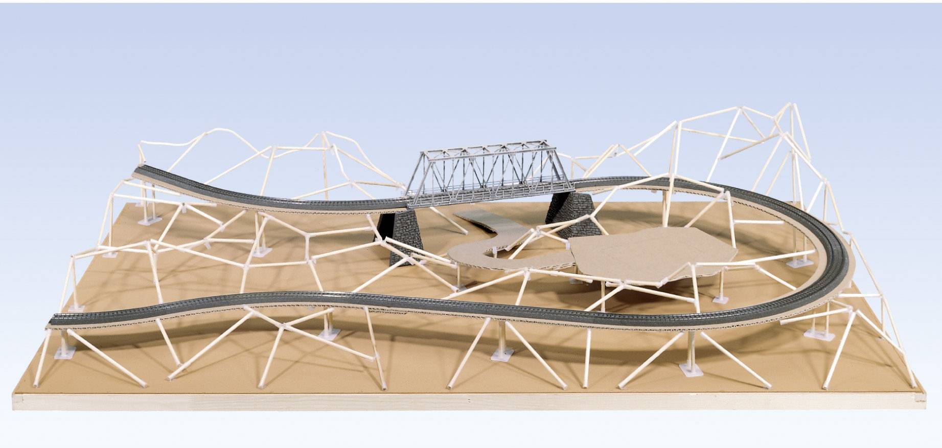 A model of a rollercoaster on a wooden platform shows intricate tracks and a bridge. It illustrates the route design.