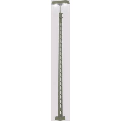 A tall grey street lamp with a rectangular base and several square openings along the pole, illuminated.