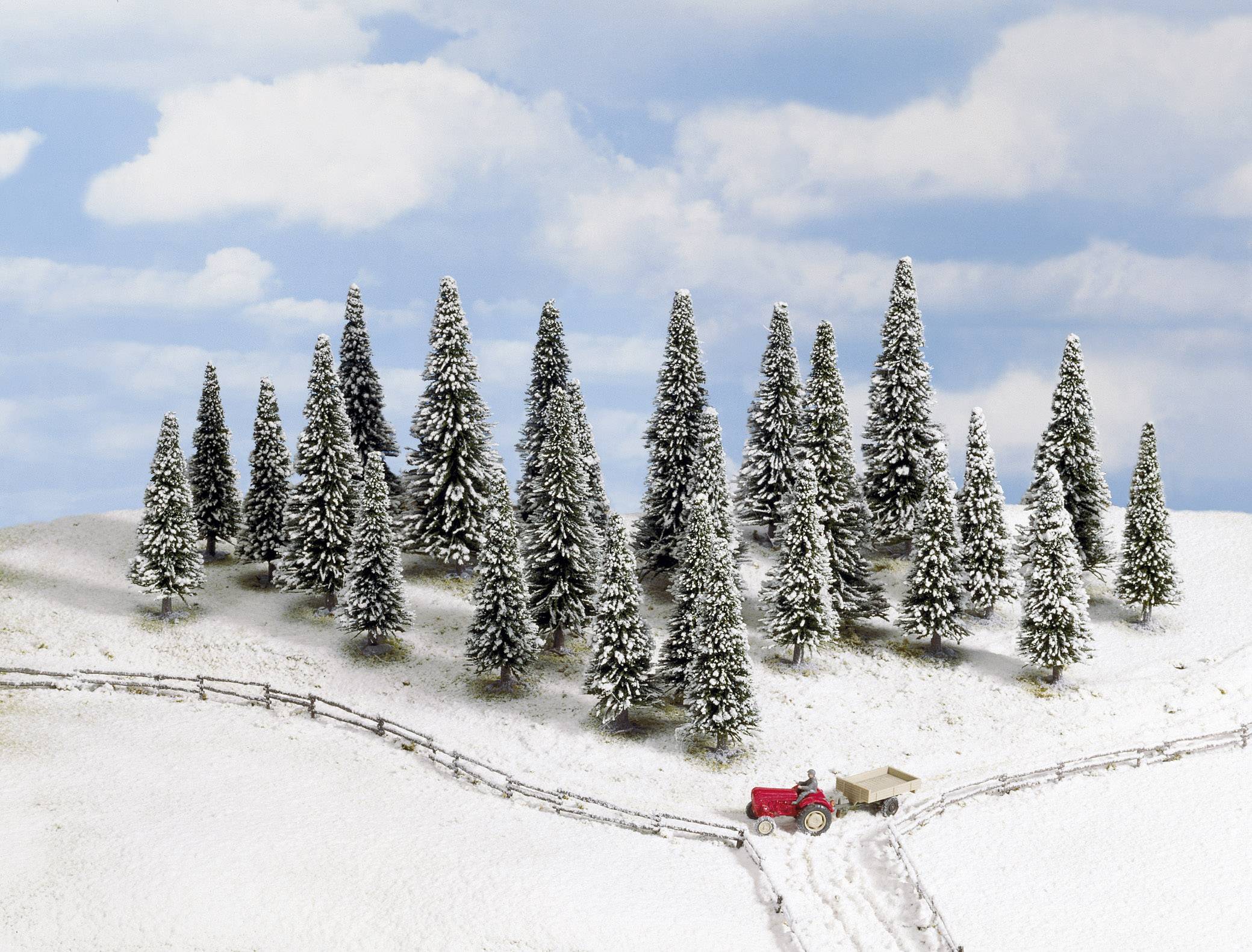 Snow-covered winter landscape with a pine forest and a small red tractor on a path. Clear sky with some clouds in the background.