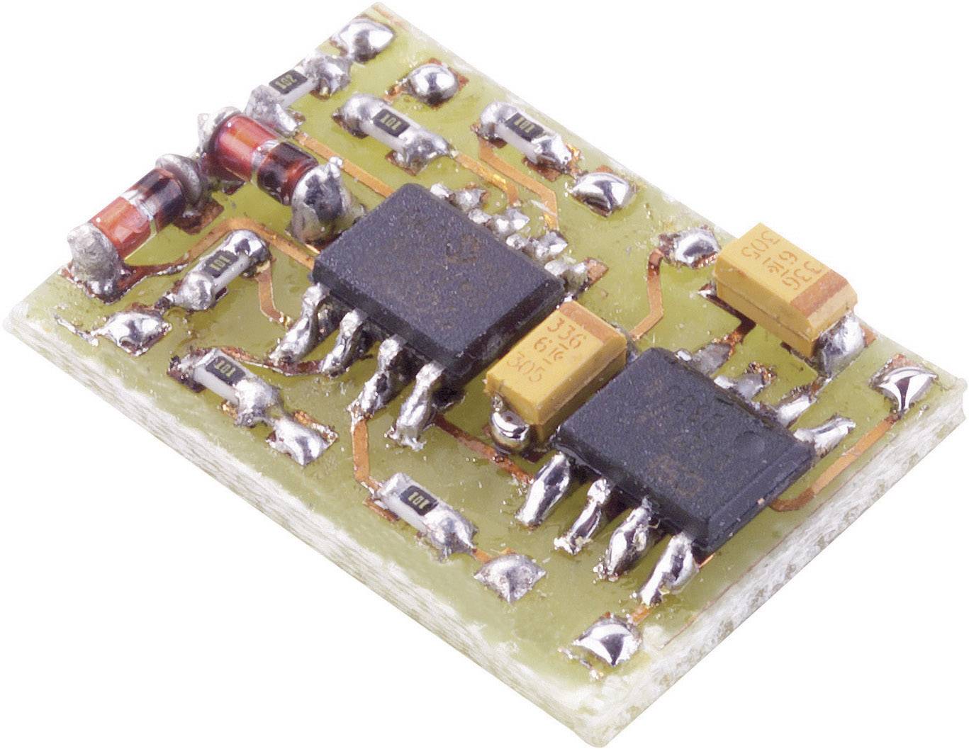 A small electronic circuit board with various microchips and components, including capacitors and resistors, on a light surface.
