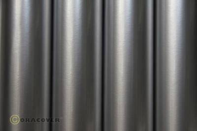 Gleaming metallic surface with vertical stripes reminiscent of stainless steel tubes. A blurred logo in the bottom left.