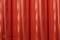 A red curtain with a glossy, vertical wavy pattern; serves as a background or decorative element.