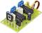 A green circuit board with several black integrated circuits, yellow capacitors, and wire connections.