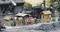Miniature railway scene with workers, buildings and a steam locomotive in a rural setting.