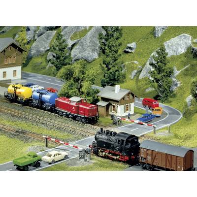 Model railway layout with a small village, tracks and two trains. A steam locomotive is pulling goods wagons, while a diesel locomotive is pulling colourful tanker cars.
