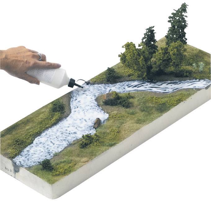 A hand is pouring liquid from a bottle over a landscape model featuring a river and trees, representing water.