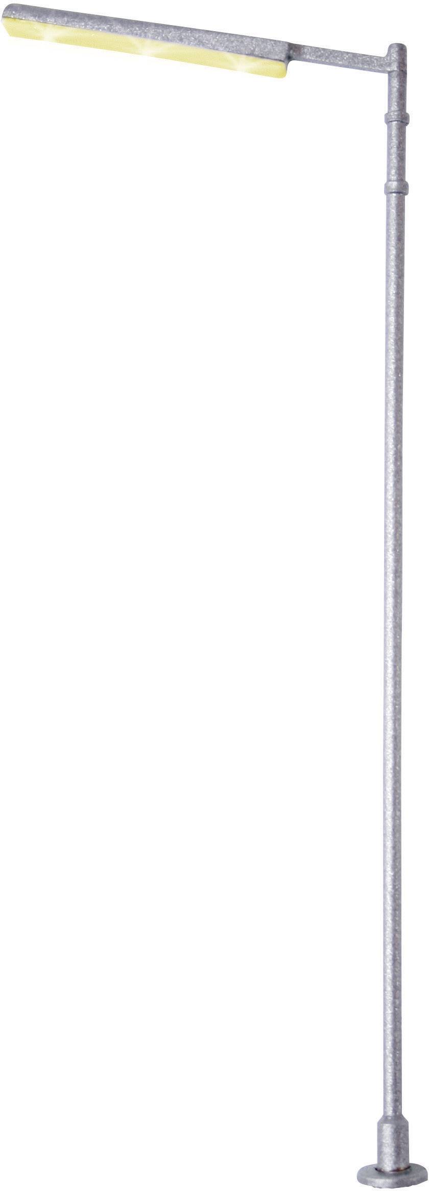 A slender, modern street lamp with a silver pole and yellow illumination strip at the top.