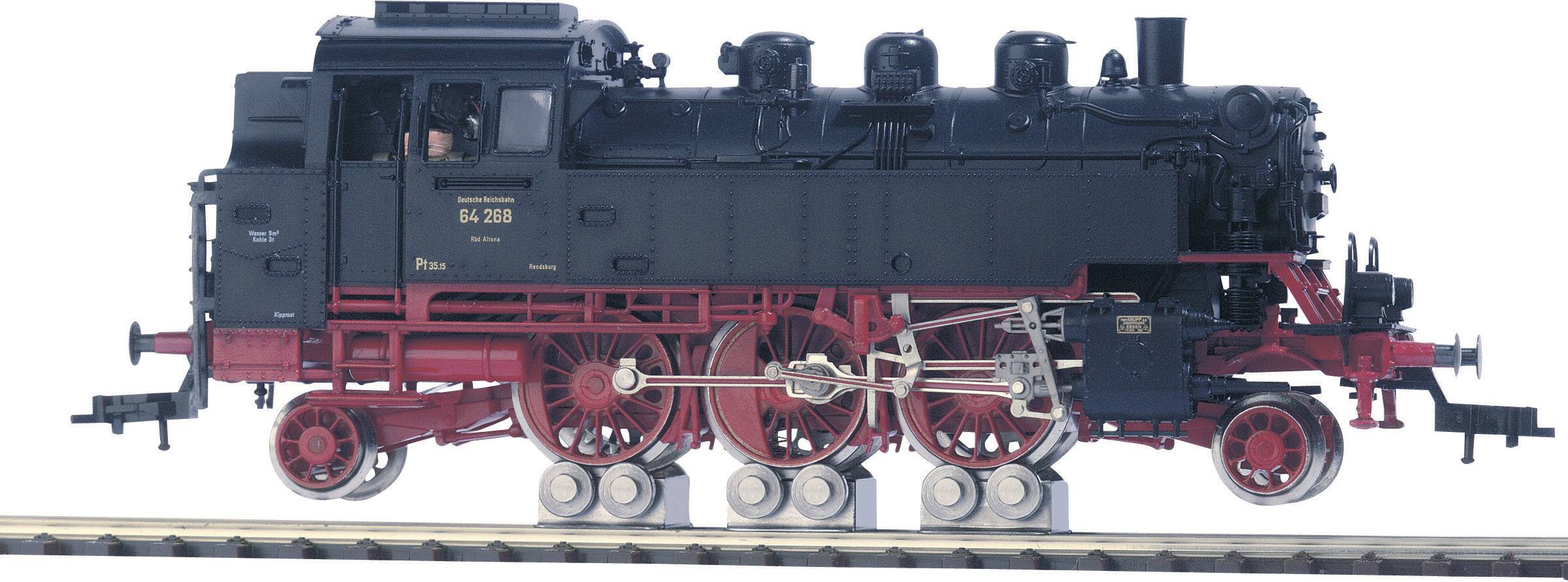 A black steam locomotive on tracks, with red wheels and visible mechanical details. A person is discernible in the driver's cab.