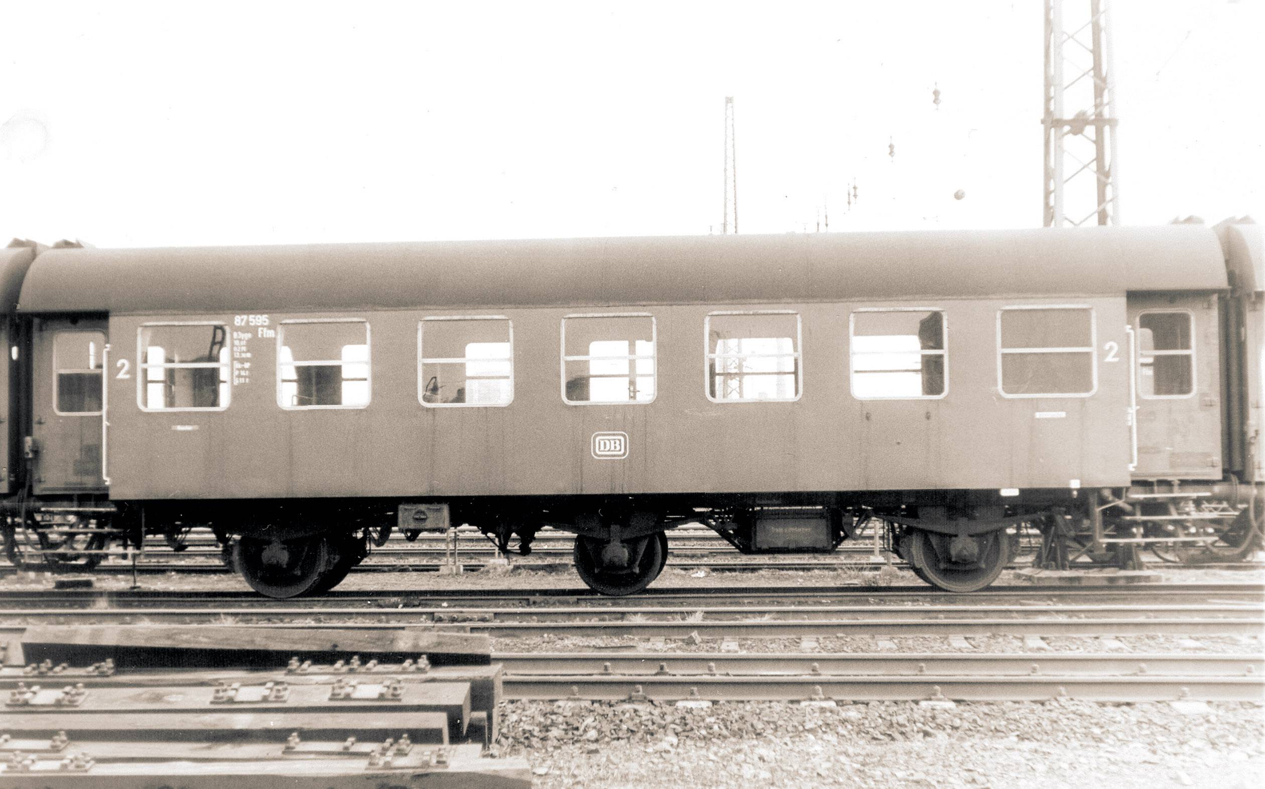 Old photograph of a railway passenger carriage on tracks, taken from the side. The carriage has multiple windows and inscriptions.