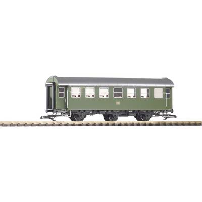 A green model railway passenger carriage on tracks, with detailed windows and doors, stands on a model railway layout.