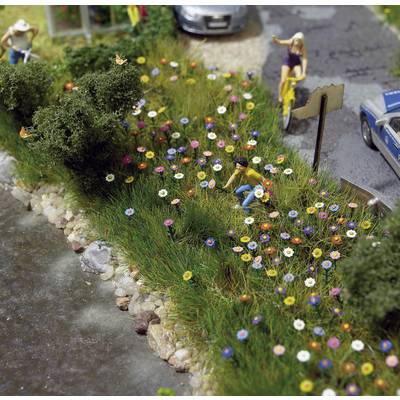 Two miniature figures are planting flowers along a path. Another car and a person can be seen in the background.