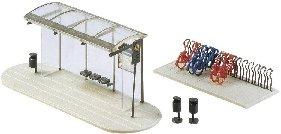 Model of a bus stop with a covered shelter and bench. Next to it are a bicycle rack with bicycles and two rubbish bins.