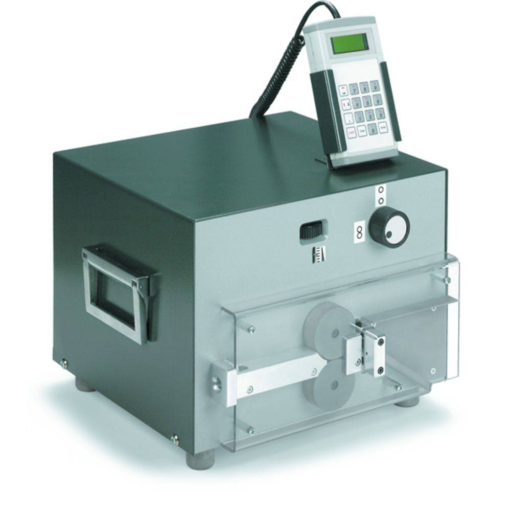 An electronic device with a digital display and keypad at the top. A transparent container at the front with visible rollers and a mechanism.