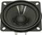A black speaker on a square mounting plate with four screw holes, viewed from above.