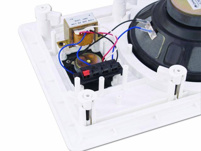 Internal view of a loudspeaker with visible wires, a black connection terminal, and a central speaker membrane.
