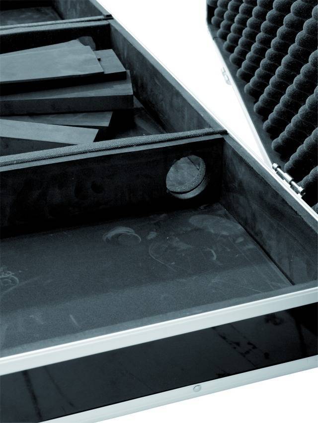 Open black suitcase with foam padding and multiple compartments. One of the compartments contains triangular foam inserts.