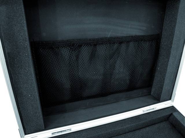 An open suitcase lined with black foam. A mesh pocket is located on the inside of the lid for storage.