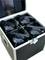 Four black stage lights are arranged in a padded transport case.
