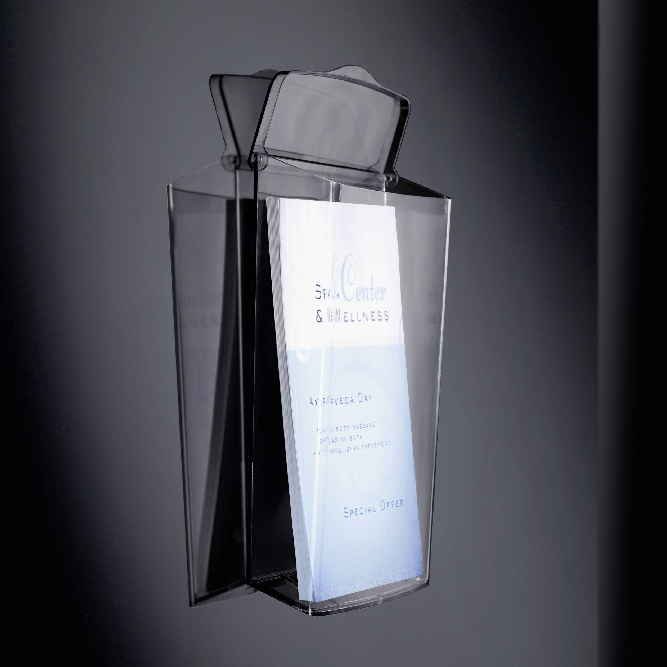 A transparent wall-mounted brochure holder contains a white and blue advertising leaflet for 'Spa Centre & Wellness' with a special offer.