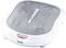 A white electric foot massager with a grey surface and a power button in the centre. Brand name 'beurer' at the bottom of the front.