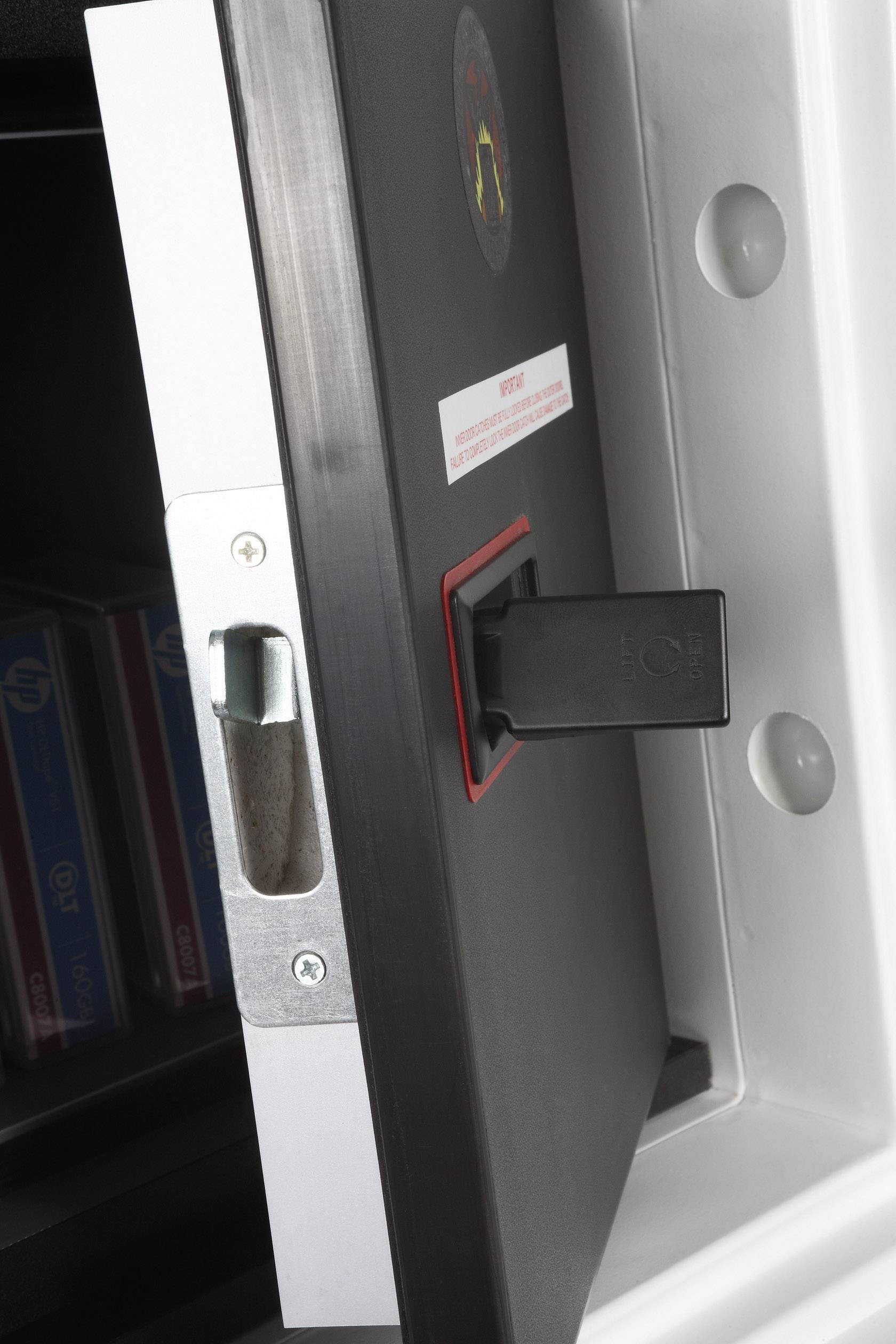 A partially open safe with a black handle demonstrates the secure storage of items, including visible folders.