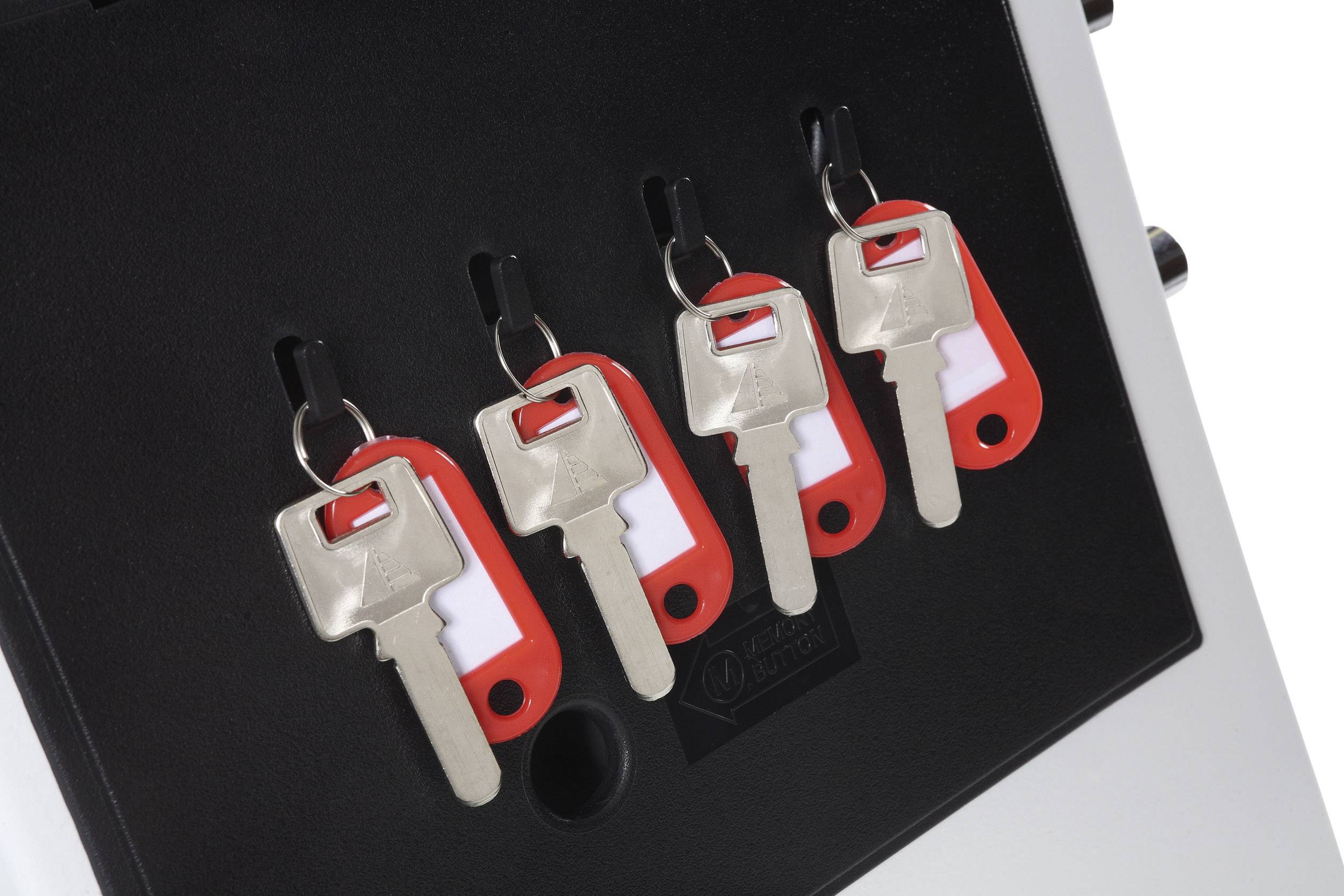 Four silver keys with red markings hang neatly on hooks on a black surface.