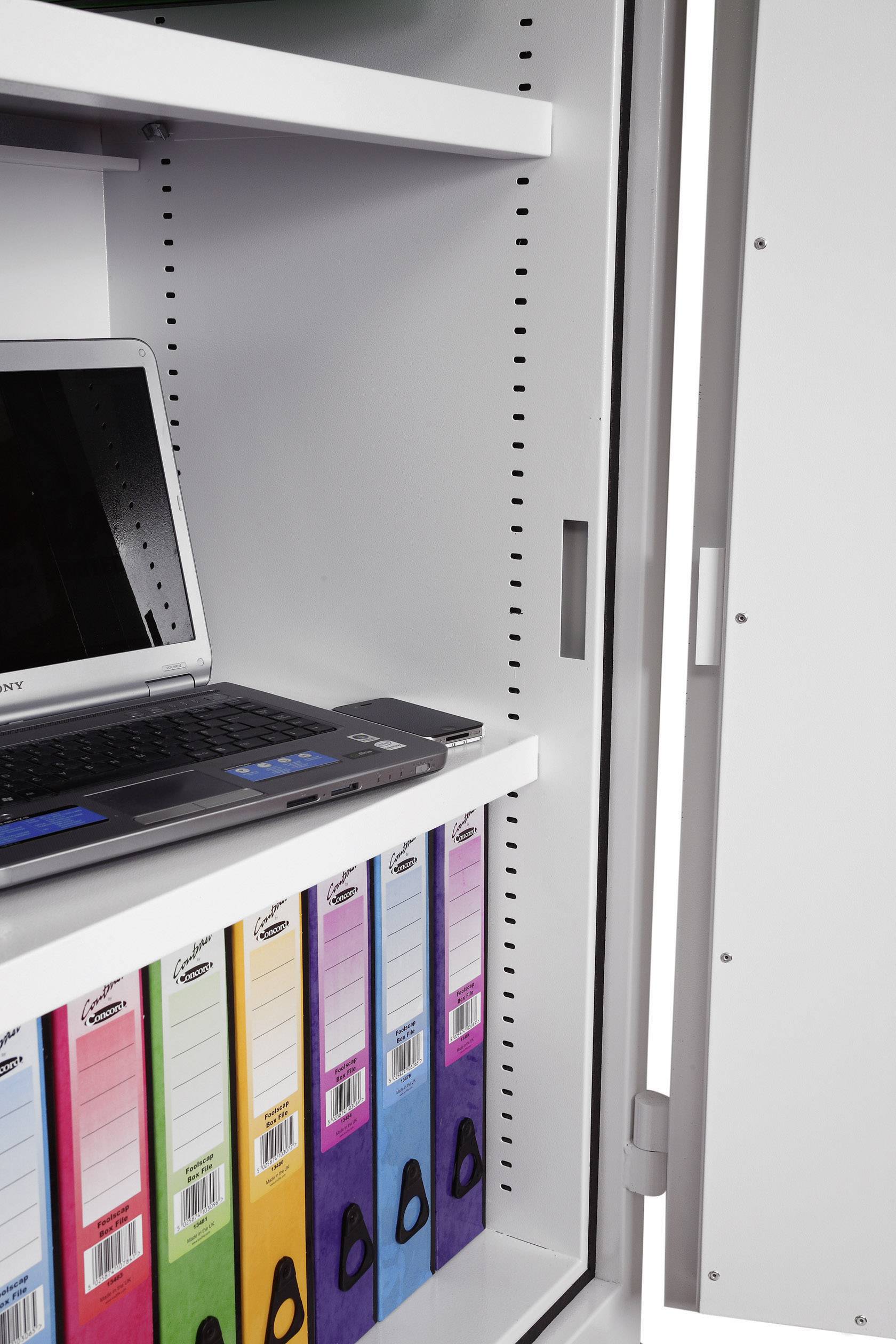 An open cupboard reveals a laptop on a shelf. Beneath it are several colourful folders.