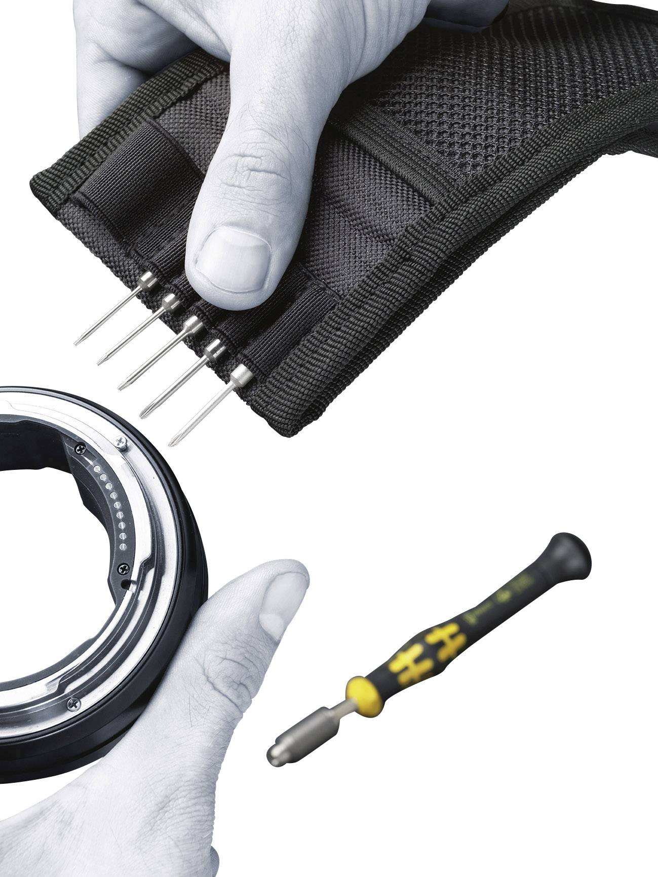 'Hands are holding a bag of metal pins and a ring. Beside it lies a screwdriver with a yellow handle on a white background.'