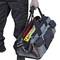 A person is carrying a grey tool bag with yellow safety details and multiple compartments.
