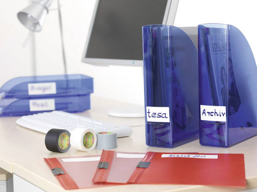 A desk with a computer, several blue and red folders, and adhesive tapes. Folders are labelled 'tesa' and 'Archive'.