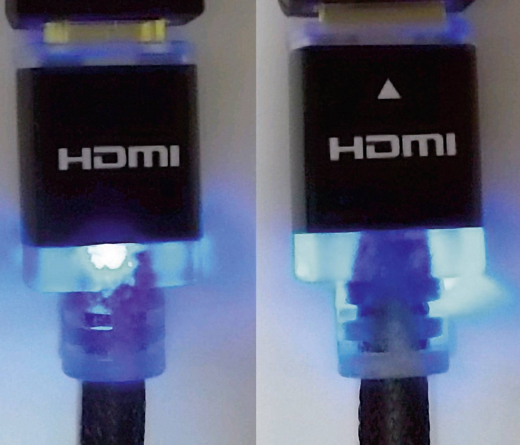 Two HDMI plugs in close-up, one showing the 'HDMI' inscription, the other additionally displaying a white arrow.