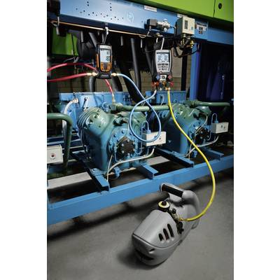 Industrial cooling system with two compressors. Diagnostic tools measure operational values. Environment appears technical and functional.