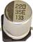 A silver electrolytic capacitor with the marking '220 35E 133', mounted on a black base, viewed from above.