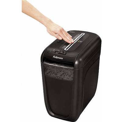 A hand is operating a black paper shredder, destroying paperclips, staples, credit cards and paper.
