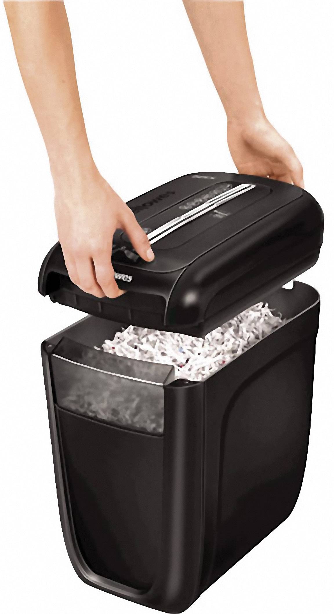 A person lifts the lid of a black paper shredder. The container is filled with shredded papers.