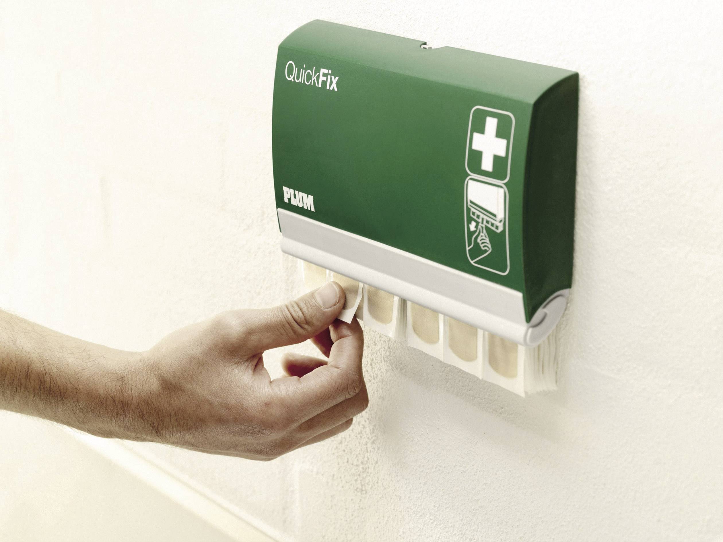 A plaster dispenser on a wall. A hand pulls out a plaster. A first aid symbol is depicted on the dispenser.