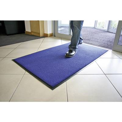 A person enters a building, steps onto a blue doormat on a light-tiled floor near a glass sliding door.