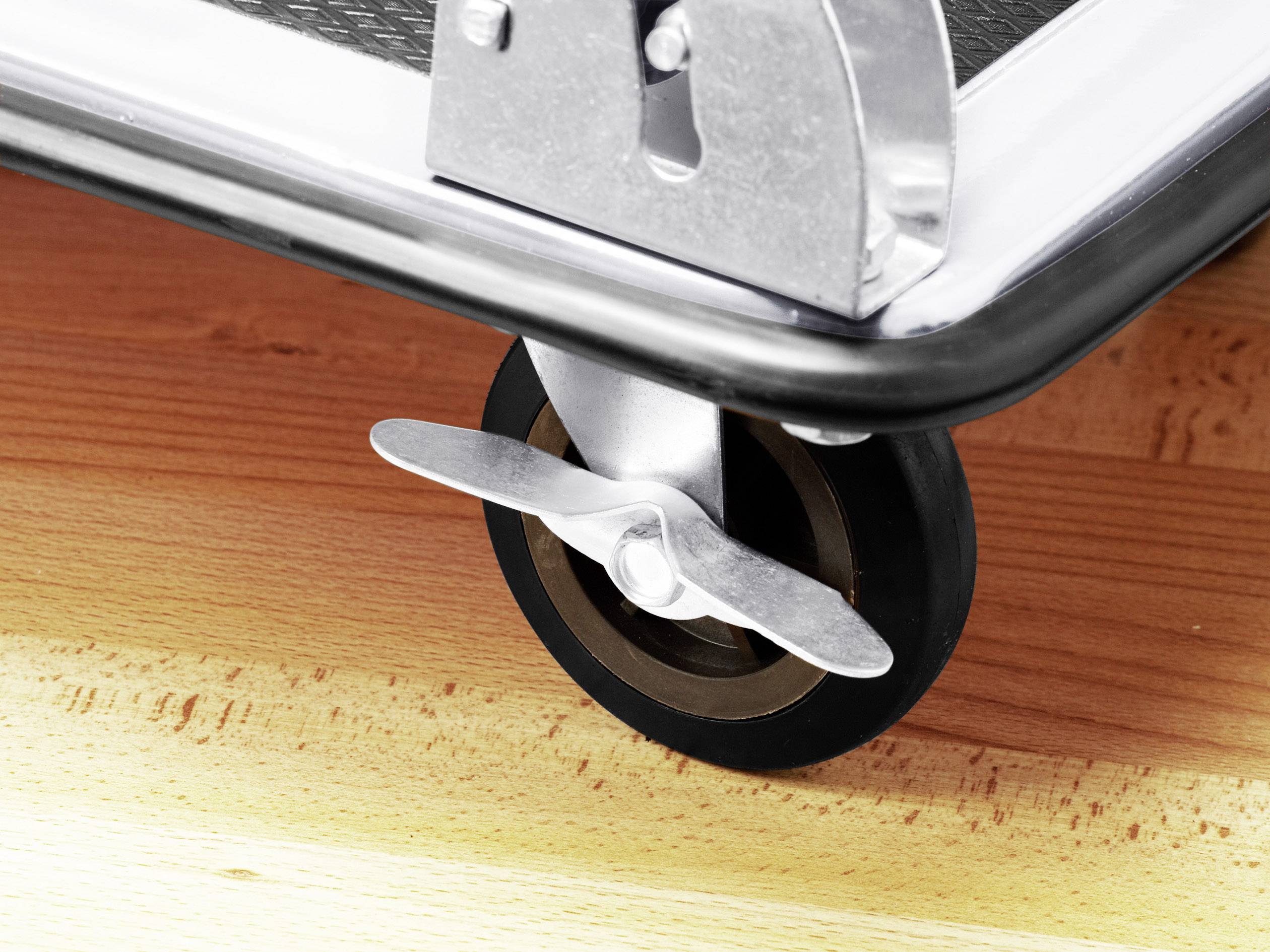 Close-up of a furniture castor on a wooden surface. The wheel is attached to a metal mounting that appears sturdy.