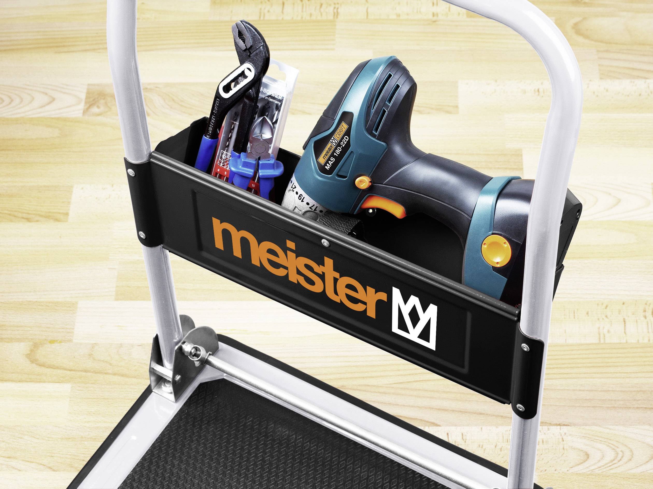 Tool kit on a step board with drill and pliers. Brand name 'meister' on the container.
