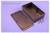 Black rectangular electronic enclosure opened, lying next to its loose lid and screws on a purple background.
