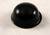 A black, hemispherical object on a light surface, possibly a furniture glider or a rubber cap.