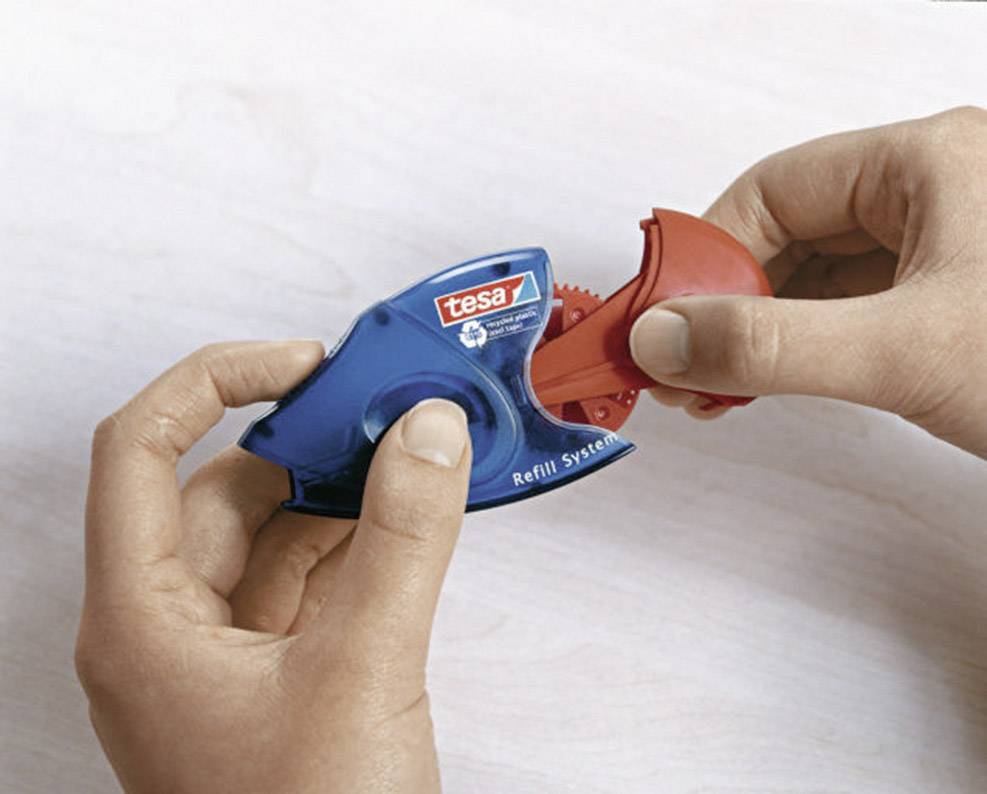 Hands are holding a Tesa tape dispenser. One hand is opening the blue housing cover to reveal the red internal mechanism.