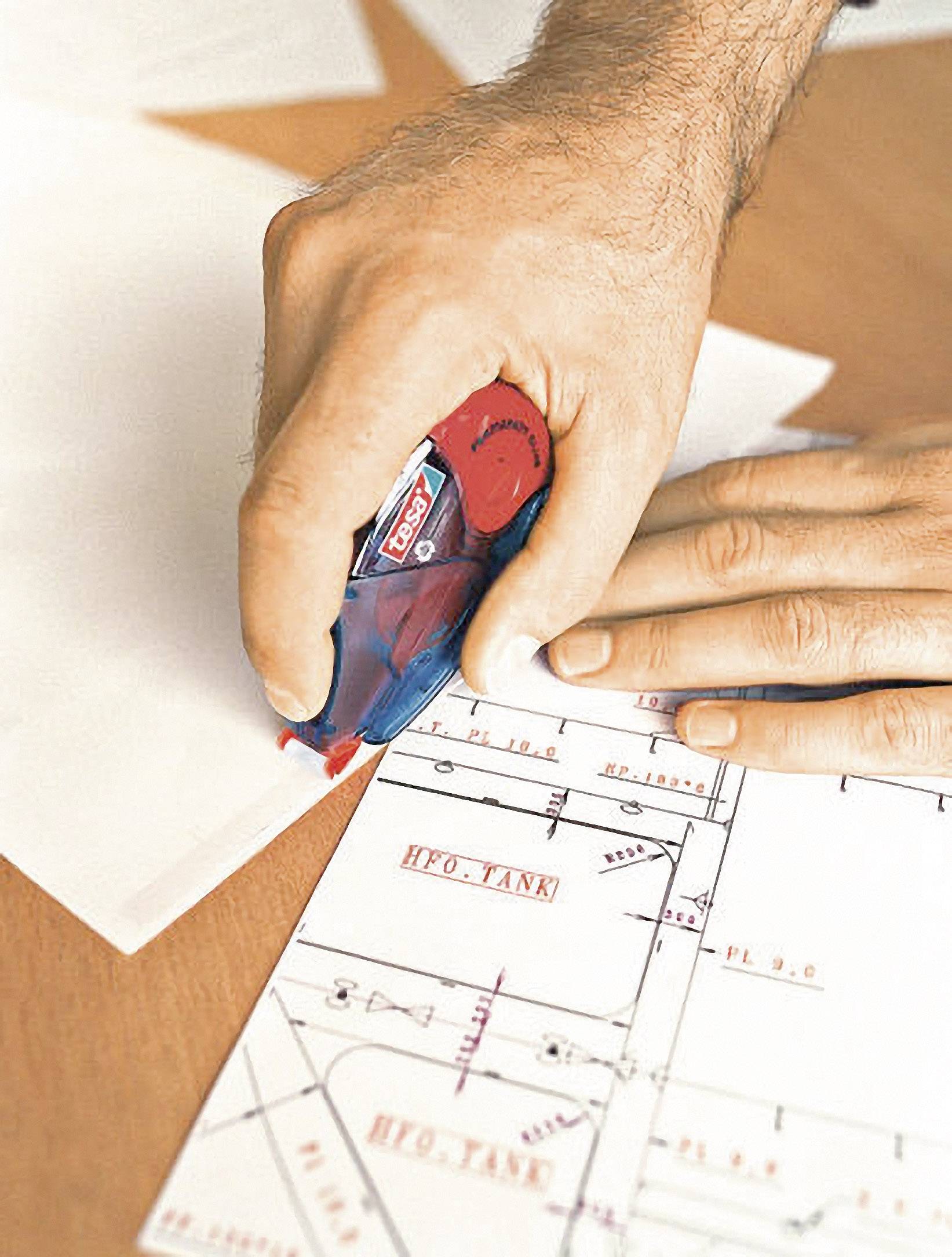 A hand is using a correction roller on a technical drawing. The drawing shows lines and labels such as 'HFO TANK'.