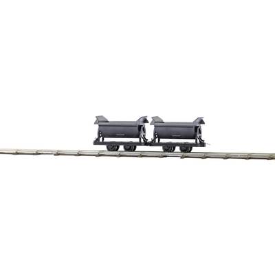 Two black mine wagons on a railway track, likely used for transporting coal or ore.