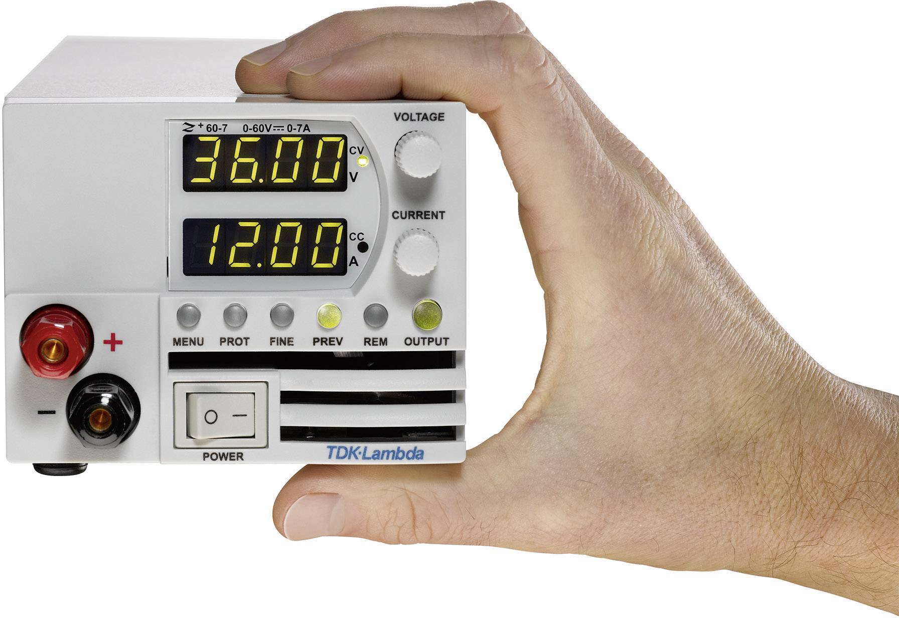 A hand is holding a small electronic device with digital displays showing voltage (36.00 V) and current (12.00 A).