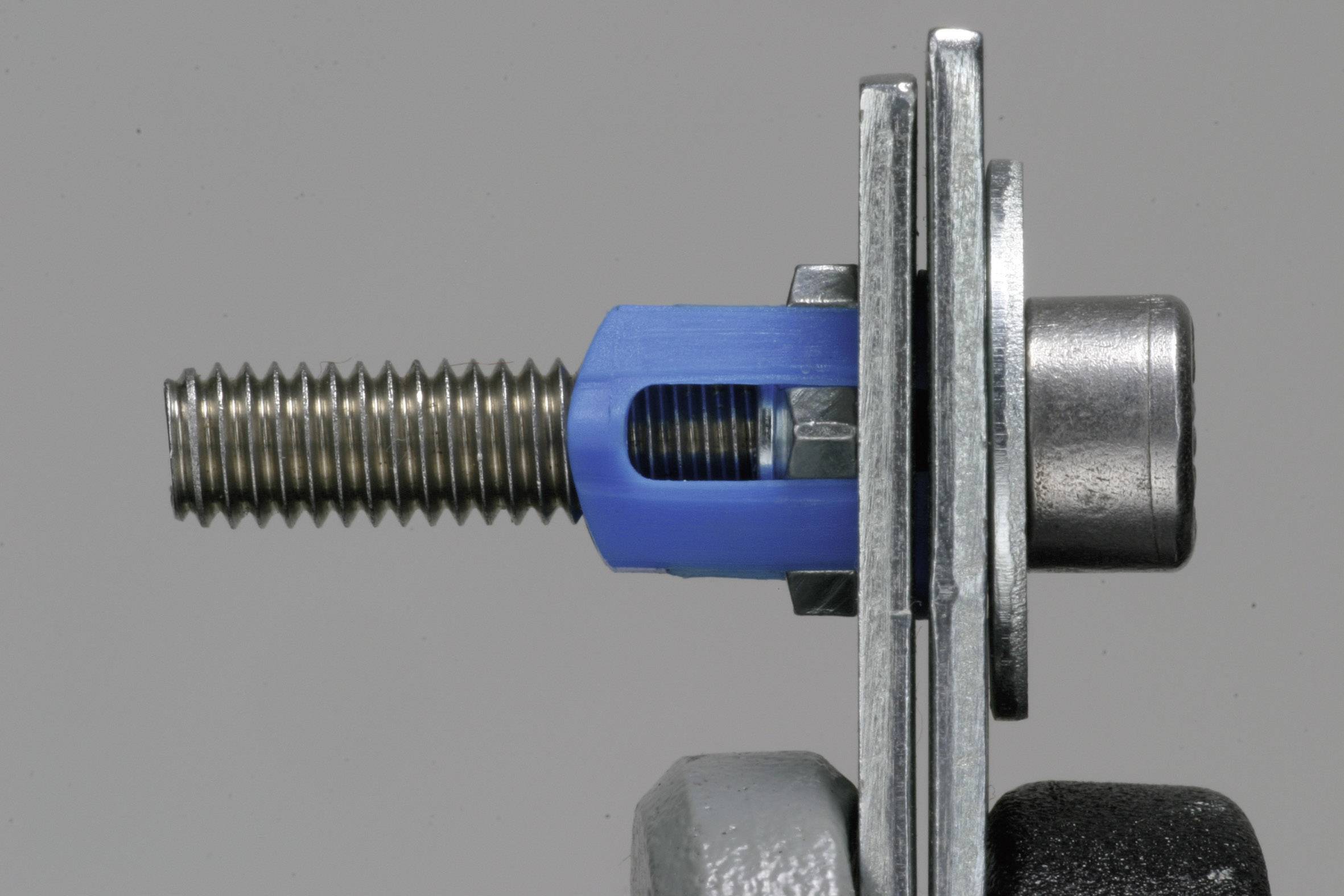 A metal screw, partially covered with a blue plastic sleeve, is secured in a metal bracket.