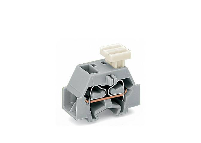 A grey plastic terminal block with metallic contacts and a small lever on top, used for connecting cables in electrical circuits.