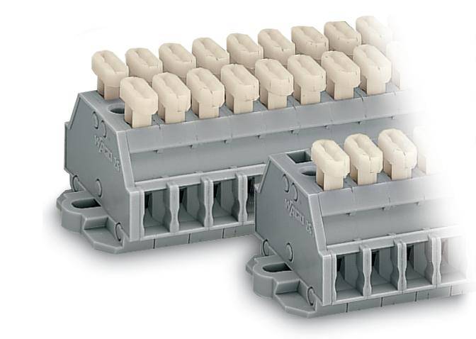 Plastic terminal blocks in grey with white terminals, arranged in two rows. They are used for connecting electrical conductors.
